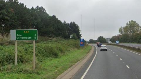 Dual carriageway of A47 with sign showing miles to Acle and Great Yarmouth