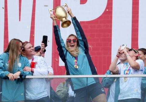  England's Zoe Aldcroft celebrates with the trophy in front of the fans during a Champions Party at Battersea Power Station, London. 