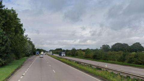 A long stretch of dual carriageway with trees flanking it on either side