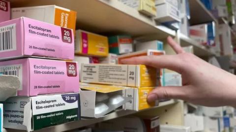 Medicines stacked on a pharmacy shelf