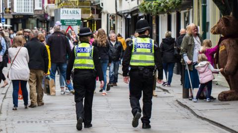 A pair of British police officers, a man and a woman, on patrol on the streets of York.