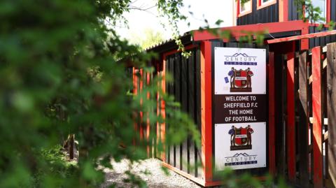 A sign on the outside of a football ground which reads 'Welcome to Sheffield FC, The Home of Football'