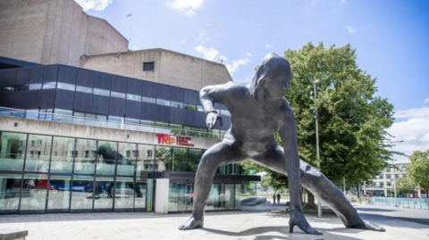 The exterior of Theatre Royal Plymouth. There is a grey statue standing outside.