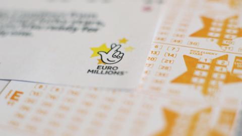 EuroMillions draw entry forms and ticket, which has yellow text and the EuroMillions fingers crossed logo in black.