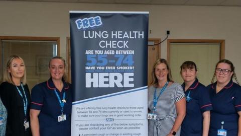 Nurses and staff at South Tyneside and Sunderland NHS Foundation Trust standing next to a banner advertising free lung health checks for those aged between 55 and 74.