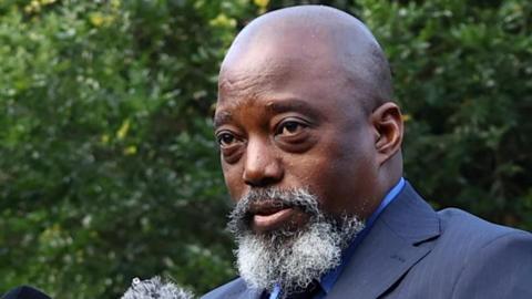 A close-up photo of Joseph Kabila with a grey beard and wearing a blue suit. His head is shaved. 