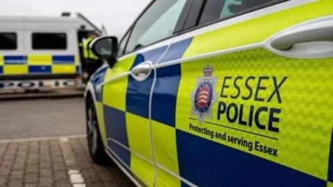 The side of an Essex Police car, which says "protecting and serving Essex" on its side.