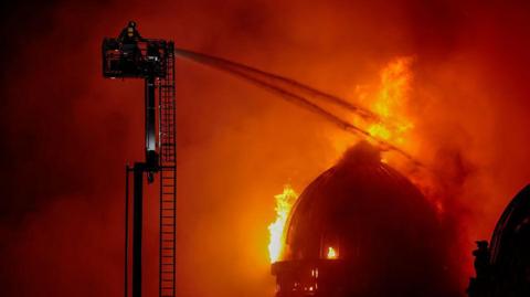 Union Street dome on fire with special appliance and firefighter spraying the flames with water