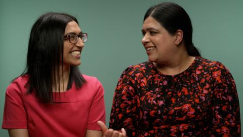 Two people turn to smile at each other