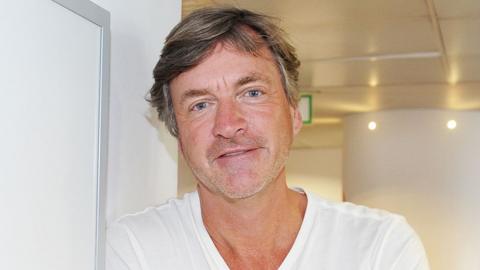 Close up of Richard Madeley wearing a white t-shirt. He is smiling