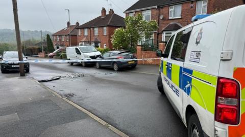 Debris in road and police tape with 999 vehicle at scene