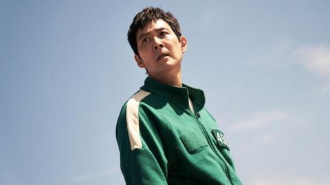 Lee Jung-jae as Gi-hun, wearing a green tracksuit against a blue background