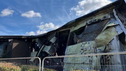 The outside of a building which is discoloured, smouldered and bent out of shape