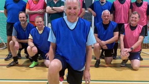 Dynamo Haslemere Walkers FC players in bibs in a sports hall.