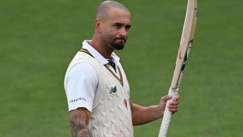 Jake Weatherald raises his bat to acknowledge applause after reaching a hundred for Tasmania