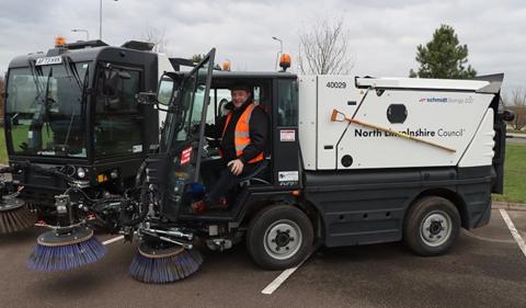 Man sitting in road sweeper.