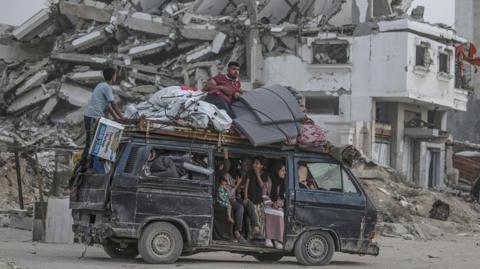 Internally displaced Palestinians leave with their belongings following an evacuation order issued by the Israeli army from the northern Gaza Strip, in Gaza City, 19 May 2025.