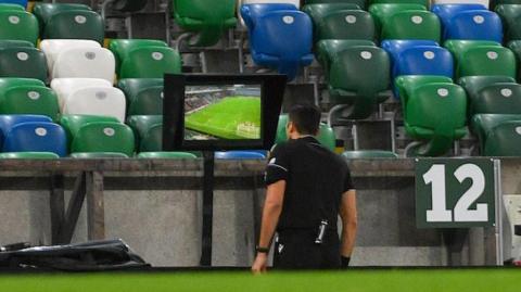 Referee looking at screen at Windsor Park