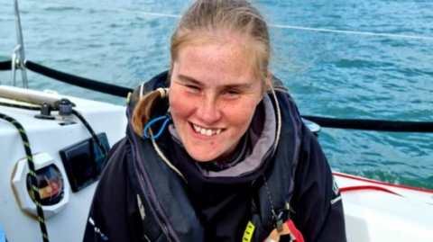 Kate Healey on a boat wearing sailing gear