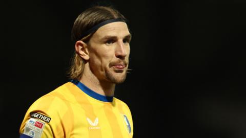Aden Flint purses his lips while playing for Mansfield Town