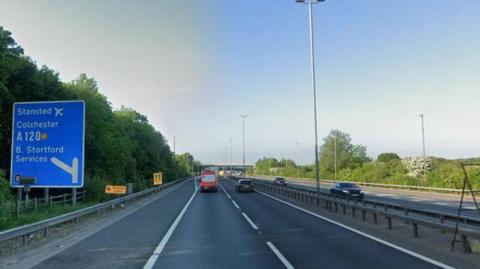 The M11 near junction eight. There are cars on the road and a blue sign  for Stansted Airport. 