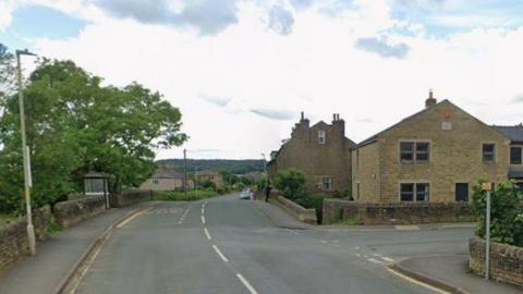 An empty T-junction. A bus stop and other street furniture can be seen.