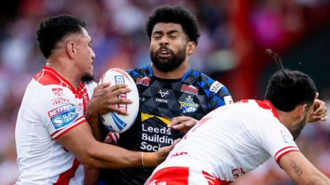 Leeds Rhinos' Kallum Watkins runs into a two-man tackle from Hull KR's Sauaso Sue and Tyrone May