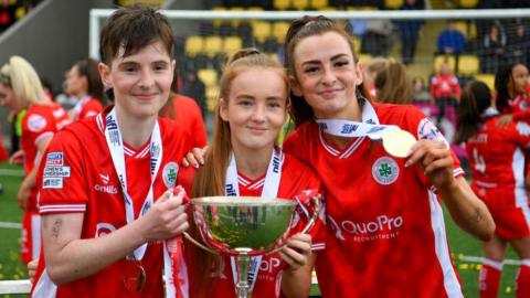 Kirsty McGuinness (left) pictured with sisters Orleigha and Caitlin after winning the League Cup