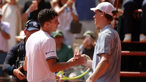 Jannik Sinner shakes hands with Juan Manuel Cerundolo
