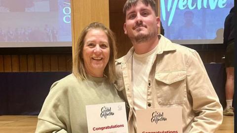 Ben Cross and his mother smiling for the camera as he is receiving his young coach of the year nomination for Oxfordshire Cricket