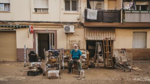  A man sits in front of his house with the belongings he was able to take from his house after catastrophic flash floods due to heavy rain in Sedavi district of Valencia, Spain