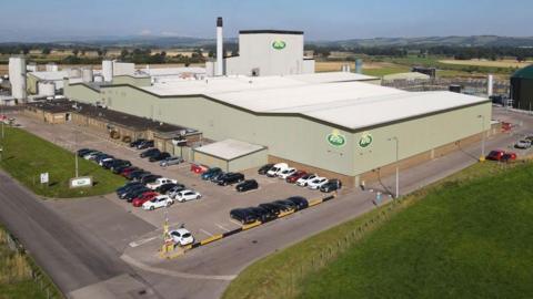 An industrial dairy building and car park set in the south of Scotland countryside