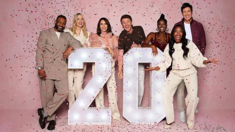 Several celebrities associated with The One Show stood behind a '20' sign against a pink background, with confetti streaming down