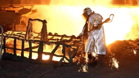 A worker taps the iron inside Blast Furnace 4 at the Port Talbot steelworks