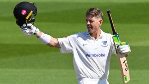 Daniel Hughes celebrates his first century for Sussex at Hove