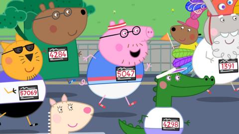 Daddy Pig wears a running vest, shorts and trainers, He is smiling as he runs alongside lots of other animals. He's wearing a running bib with the number 5047 on it