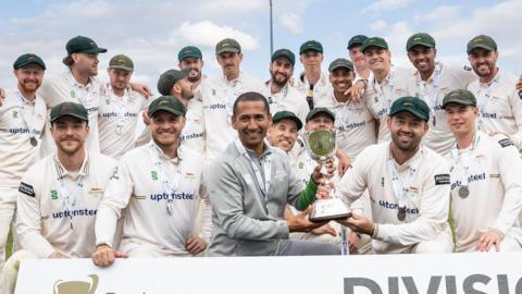 The Leicestershire squad pose with the County Championship Division Two trophy after winning it in 2025