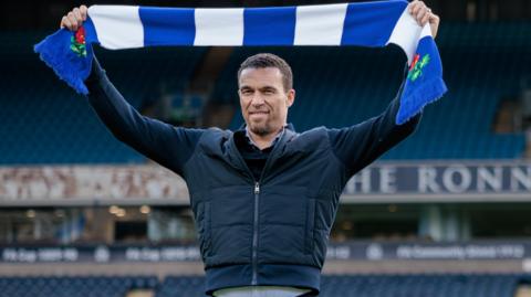 New Blackburn Rovers boss Valerien Ismael holds up a club scarf at Ewood Park