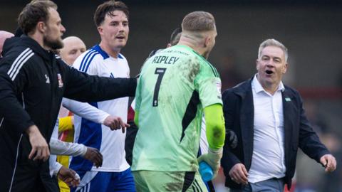 Former Crawley manager Scott Lindsey argues with Swindon goalkeeper Connor Ripley after the full-time whistle