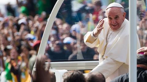Pope Francis waves from the Popemobile as he arrives to celebrate Mass on Copacabana Beach in 2013