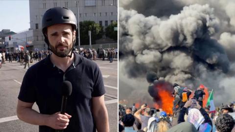 BBC's Carl Nasman is talking to a camera reporting on the immigration protests.