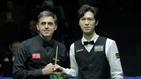 Ronnie O'Sullivan and Thepchaiya Un-Nooh bump fists before the start of their World Open final