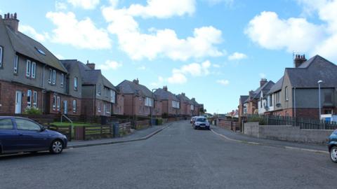 A street in Stranraer with rows of houses and cars parked outside