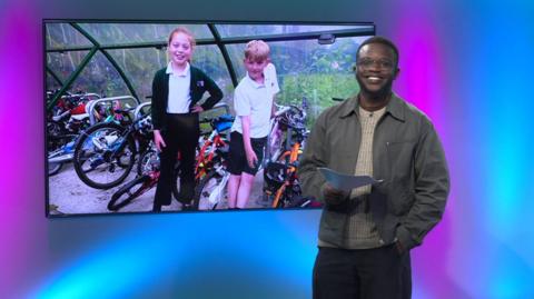 De-Graft in the studio with two children in the screen