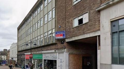 A street view of Regent Street in Mansfield. There is an office block above a row of shops.