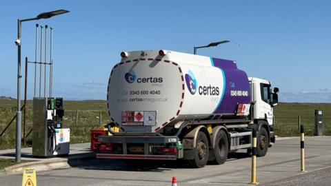 The tanker has white and purple livery and the company's name, Certas, on the side and rear of its fuel tank.