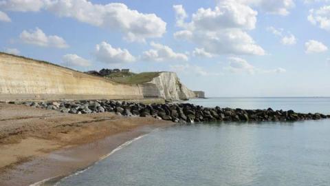 A stretch of a beach with rock pools.