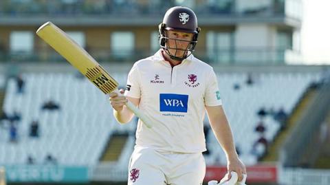  James Rew raising his bat as he walks off following his dismissal for 152.
