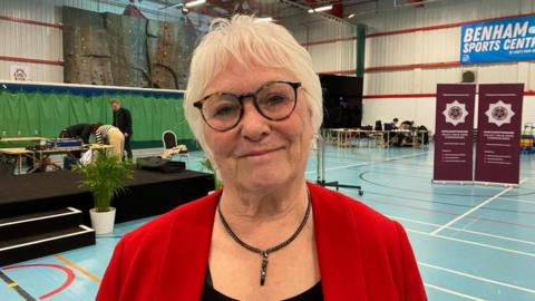 Danielle Stone with light-coloured hair and red top in a sports hall