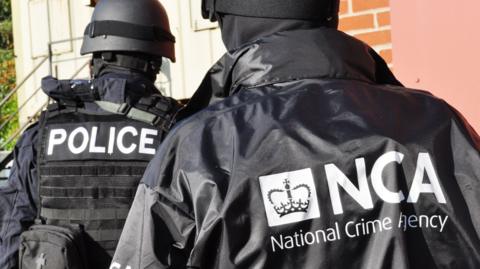 A generic photo of a police officer and a National Crime Agency officer in dark clothing